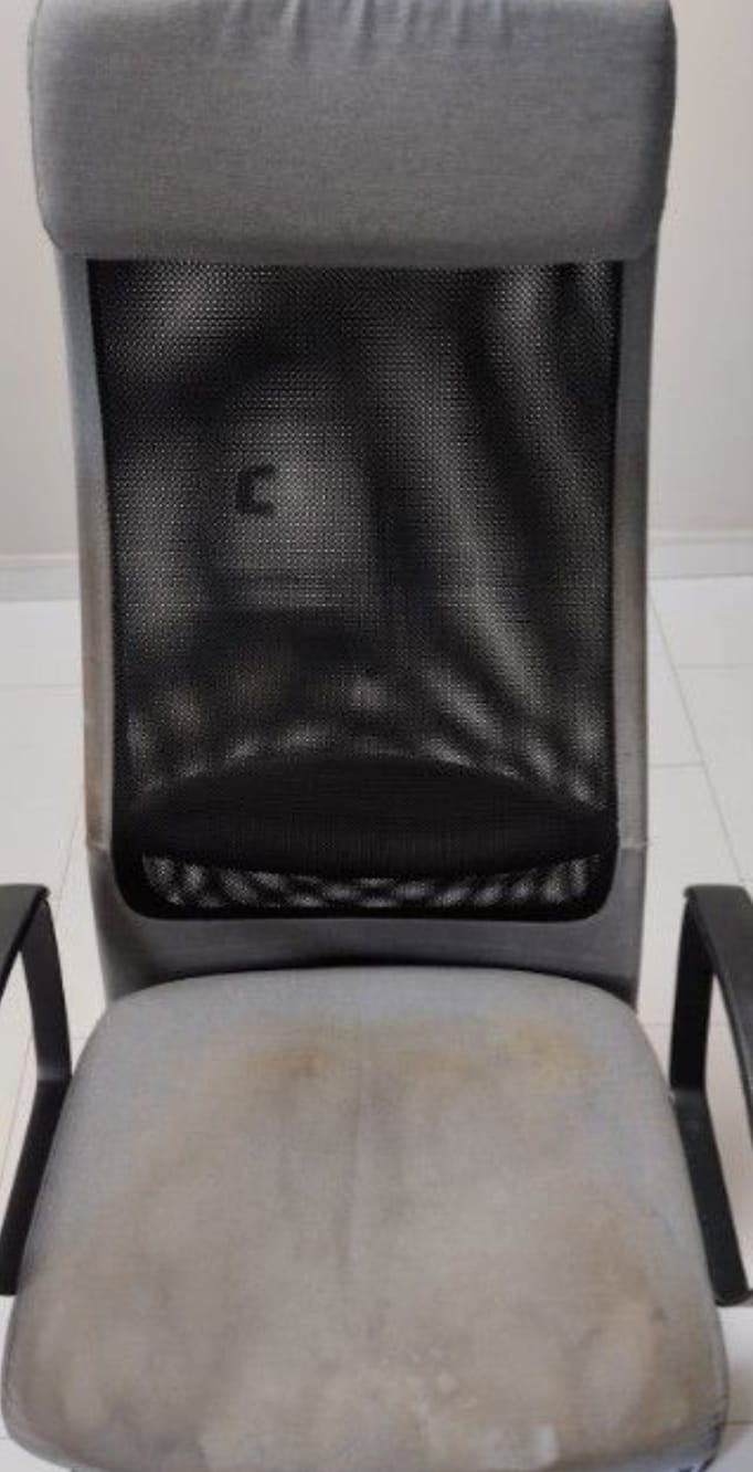 An office task chair before cleaning, the seat greyed and stained