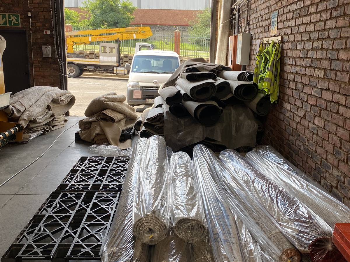 Cleaned rugs rolled and wrapped by the loading door, ready for delivery
